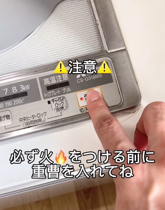 コンロのパネル操作をする人