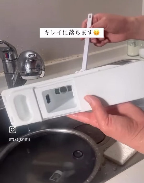 製氷機を細いブラシで洗っている様子