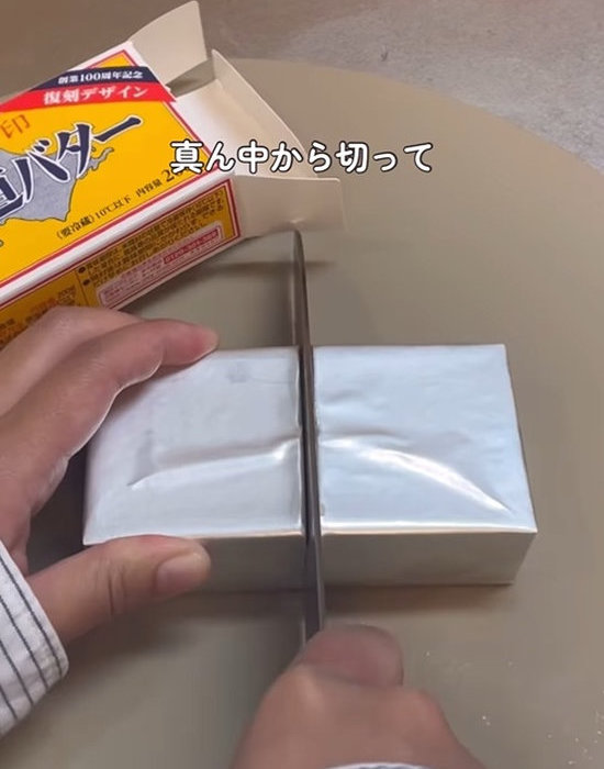 銀紙の上からバターの真ん中に包丁を入れる様子