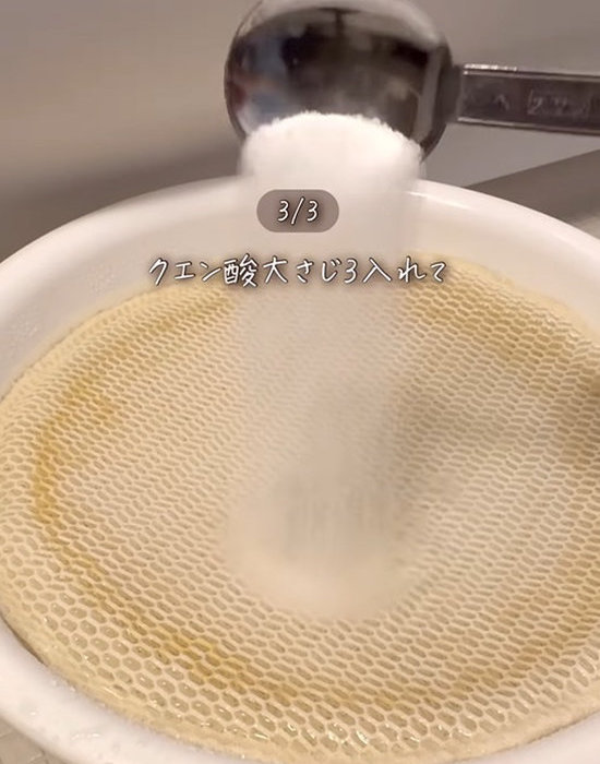 お湯に浸けた加湿器のフィルターにクエン酸を入れている様子