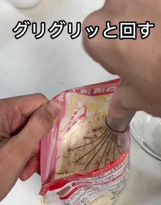 小麦粉の袋の中に泡立て器を入れている様子