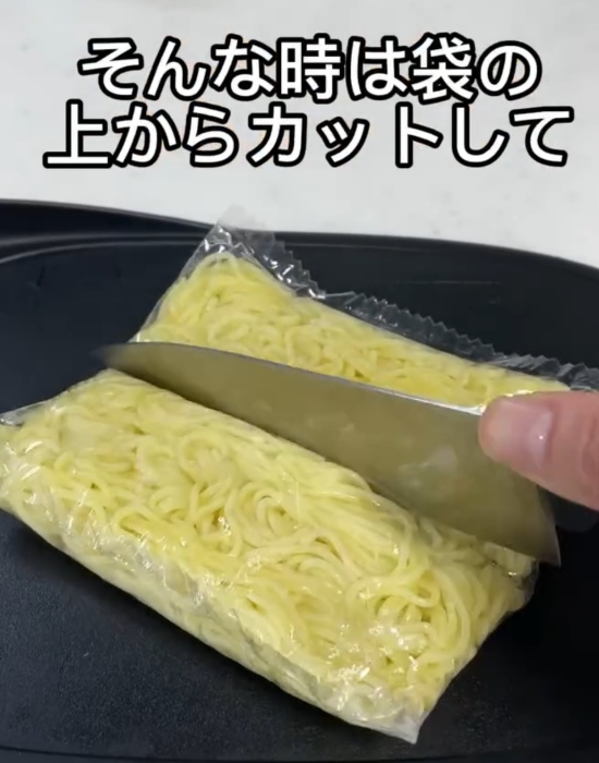 焼きそばの麺を袋の上から切っている様子