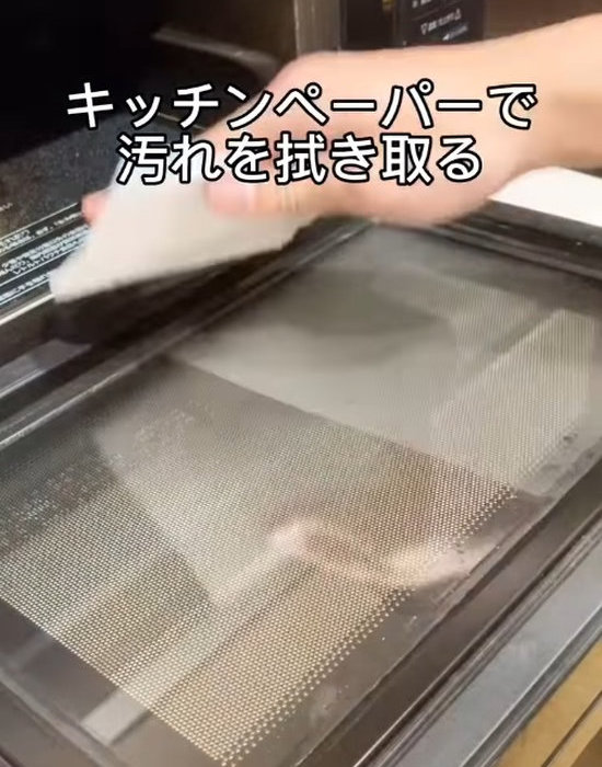 キッチンペーパーで電子レンジを拭く様子