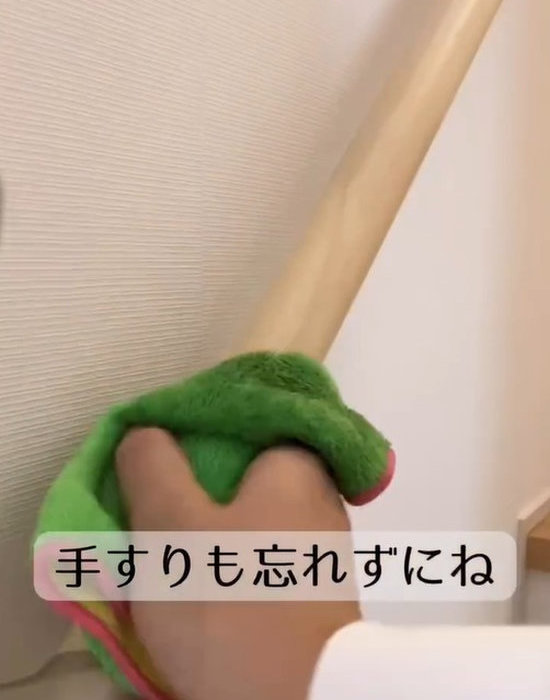 階段の手すりを布で拭く様子