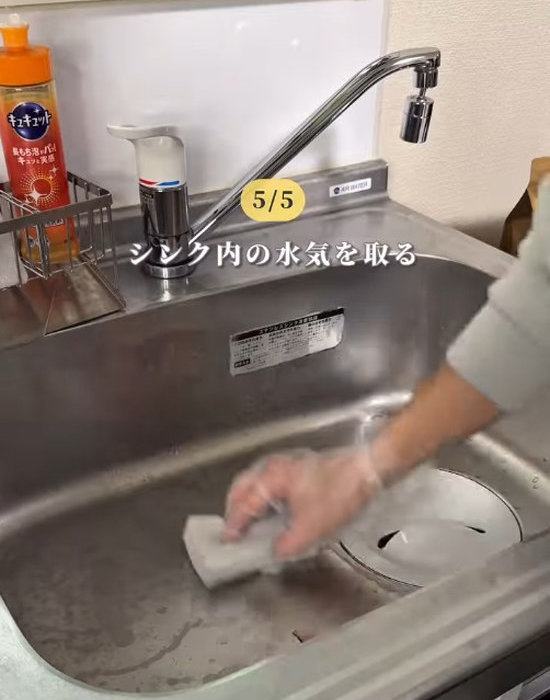 シンクの水気をていねいに拭き取っている様子
