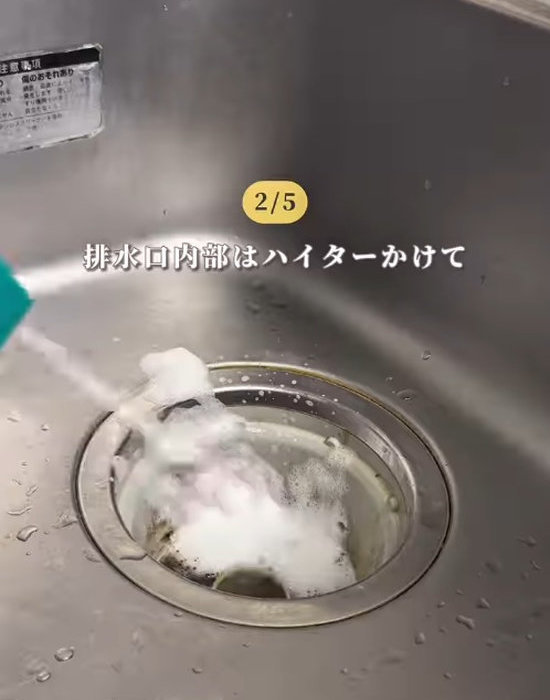 排水口にキッチンハイターをスプレーしている様子