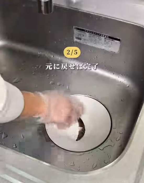 排水口のパーツを元に戻している様子