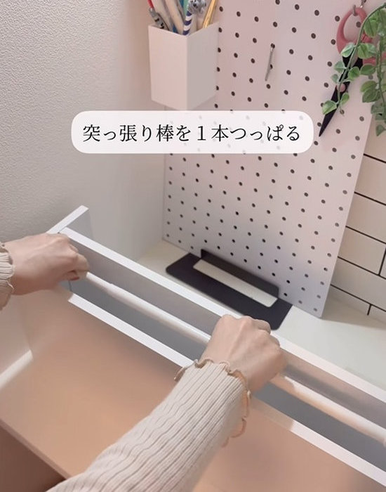 棚の裏面に突っ張り棒を設置する様子