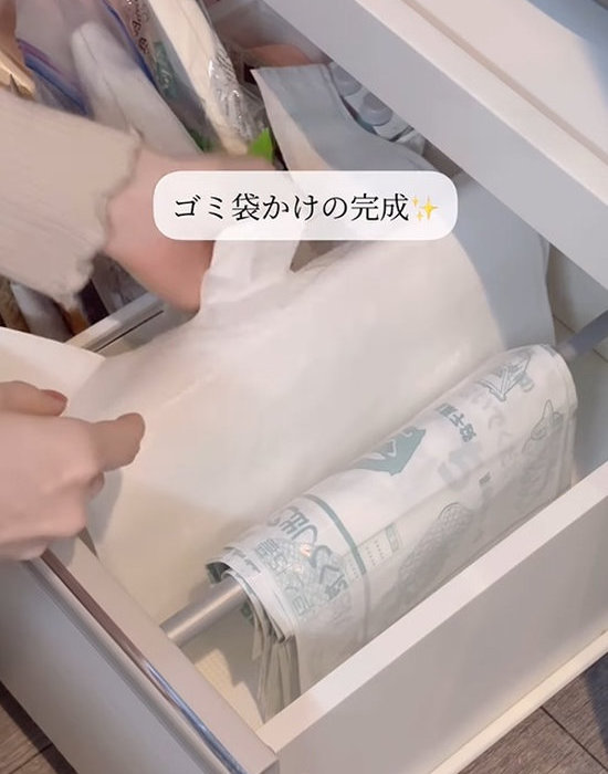 引き出しに設置した突っ張り棒にゴミ袋を掛ける様子