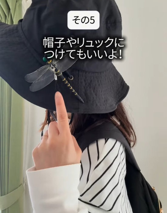 オニヤンマのおもちゃを帽子に付けた女性