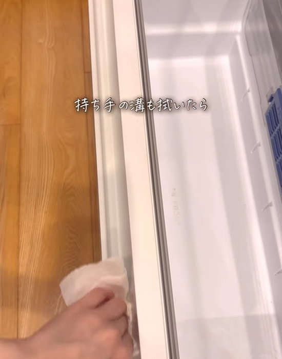 冷蔵庫の取っ手をキッチンペーパーで拭く様子
