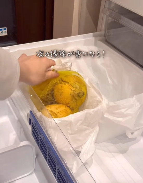 袋を付けた野菜ストッカーにタマネギを入れる様子