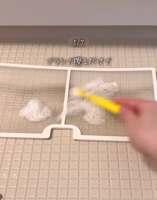 お風呂のフィルターをブラシで洗う様子