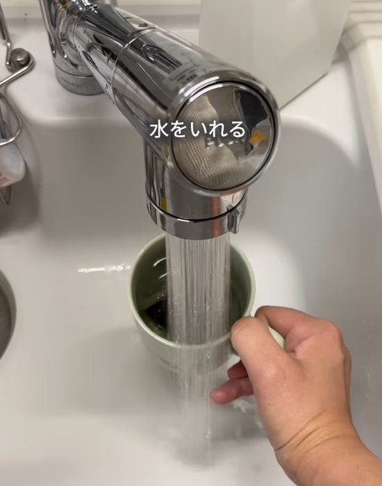 麦茶パックが入ったコップに水を入れている様子