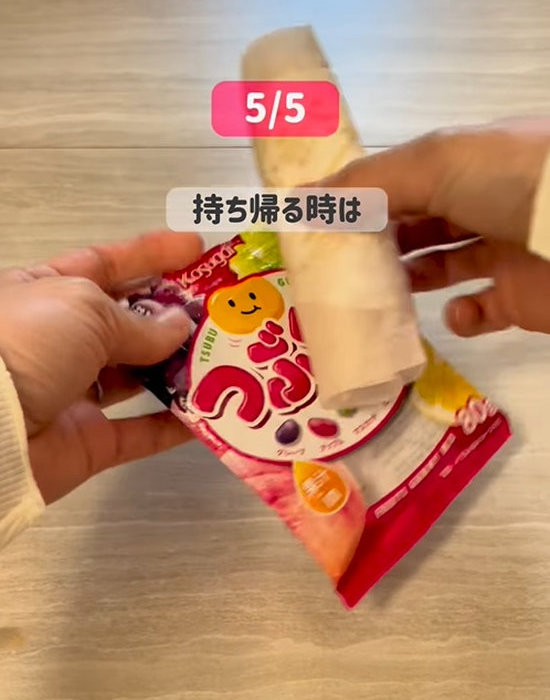 お菓子の空袋にナプキンを入れる様子