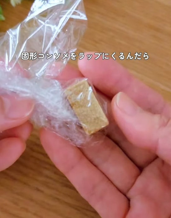 ラップで包んだ固形コンソメを手にしている様子