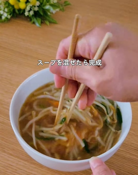 どんぶりの中の麺とスープを混ぜる様子
