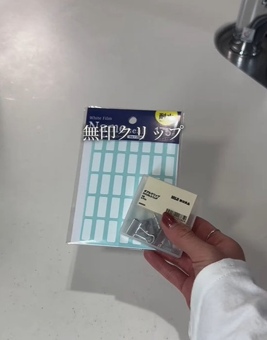 無印良品のダブルクリップとラベルシールを手にしている様子