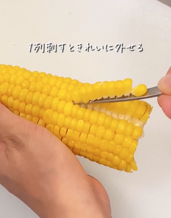 スプーンの持ち手をトウモロコシに差し込む様子