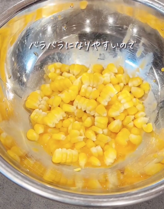 ボウルでトウモロコシの粒と卵黄と小麦粉を混ぜる様子