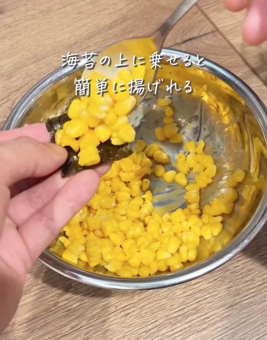 海苔の上にトウモロコシの粒をのせる様子