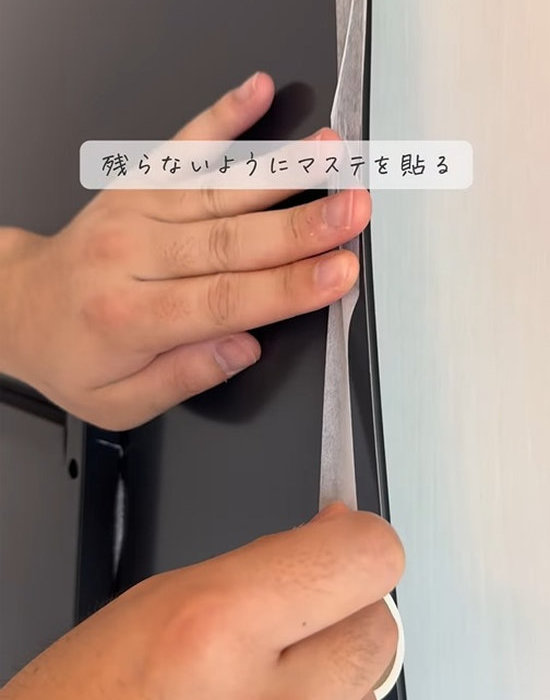 鏡のふちにマスキングテープを貼る様子