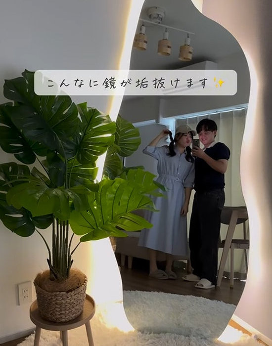 テープライトを貼った鏡に映る男女