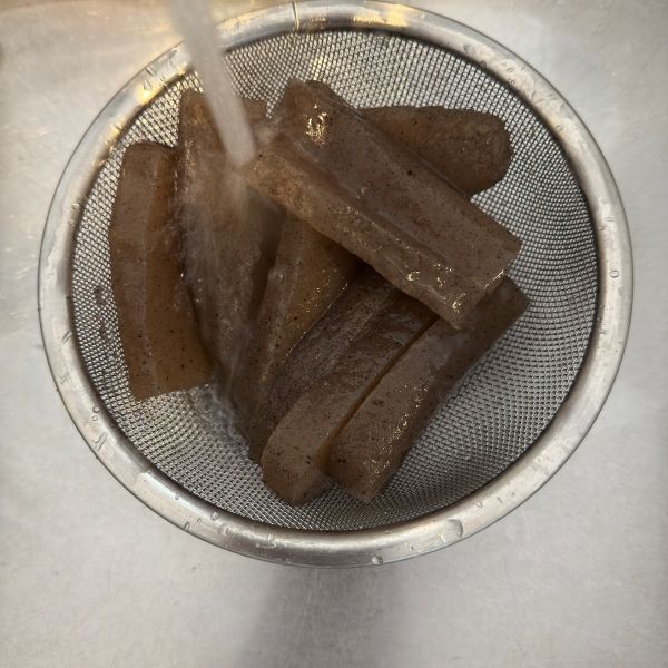こんにゃくをザルにあげて水洗いする様子