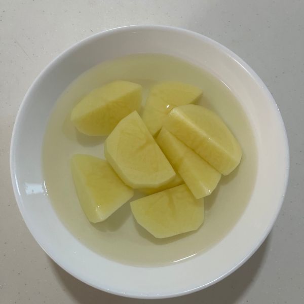皮をむいてひと口大に切ったジャガイモを水にさらす様子