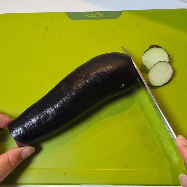 ナスの底とヘタを包丁で切り落とした様子