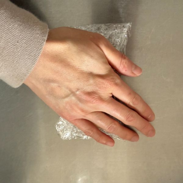 ラップに包んだバナナを手のひらでつぶす様子