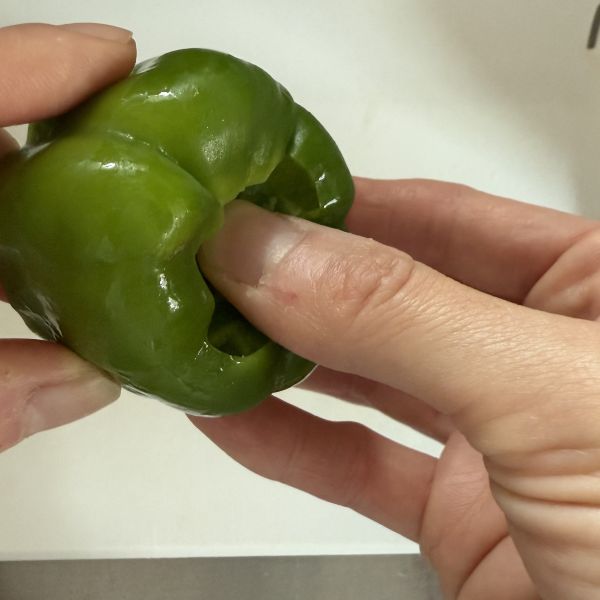 ピーマンのヘタを親指で中に押し込んだ様子