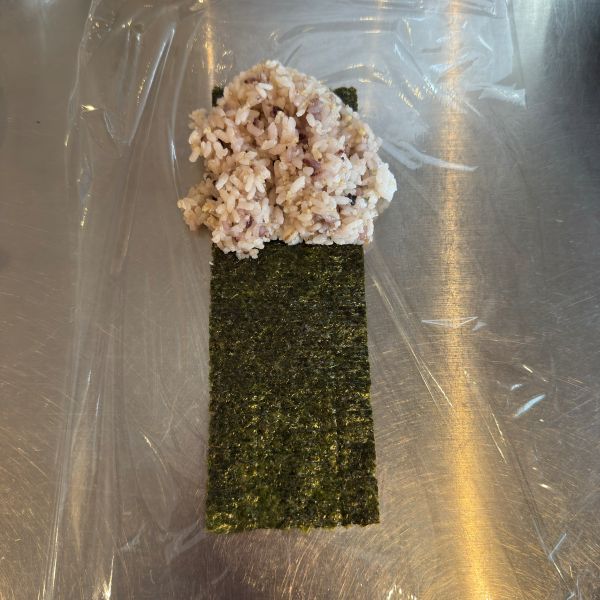 ラップの上に置いたのりの上部にご飯をのせた様子