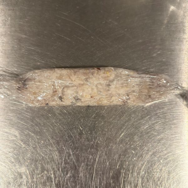長方形の形になるように置いたご飯をラップで巻いた様子