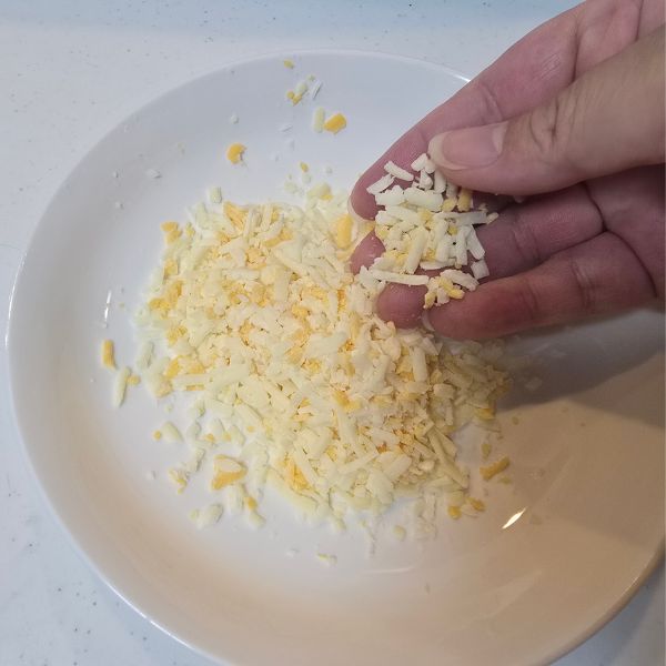 冷凍したピザ用チーズを皿に出して触っている様子