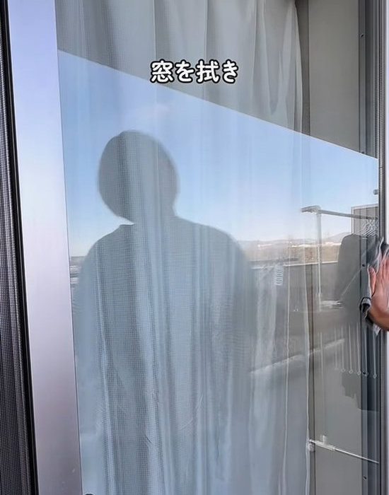 クロスで窓を拭く様子