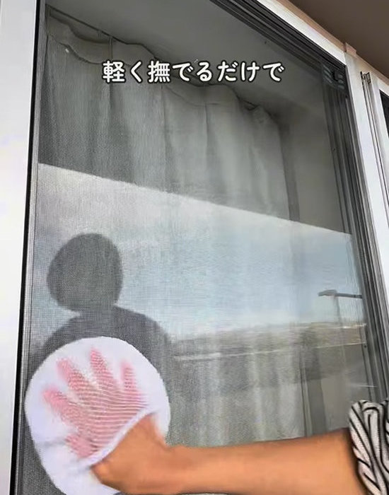 網戸をミトンでなでて拭く様子