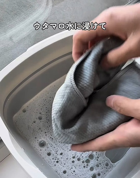 バケツに入った水にクロスを浸す様子