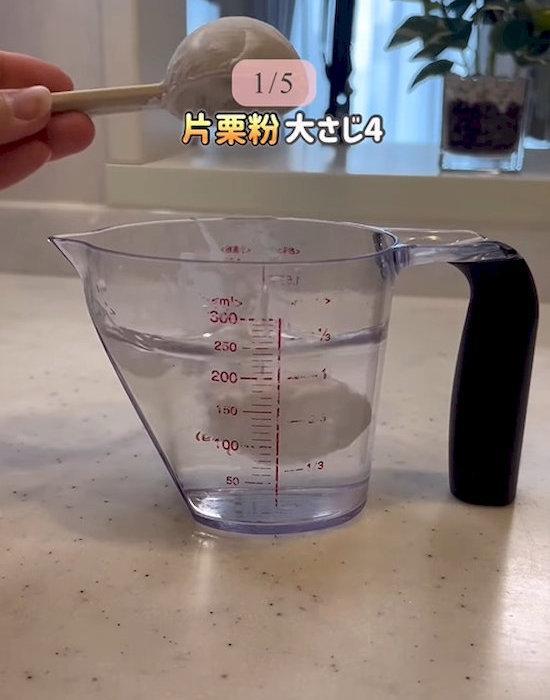 水の入った計量カップに片栗粉を入れる様子