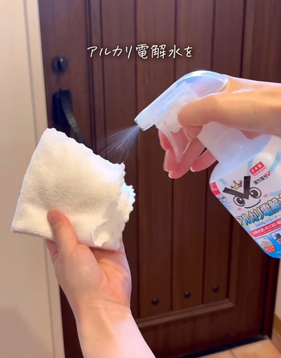 クロスにアルカリ電解水を吹き付ける様子