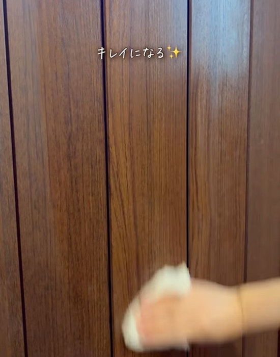 玄関扉をクロスで拭く様子