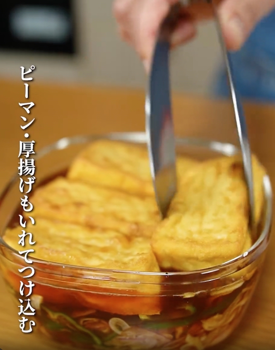 タレと野菜の入った器に厚揚げを入れる様子