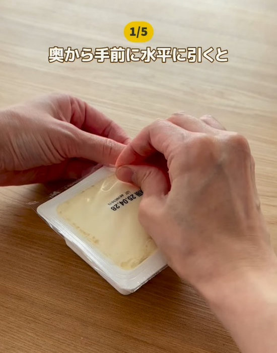 パック豆腐の蓋を奥から開ける様子