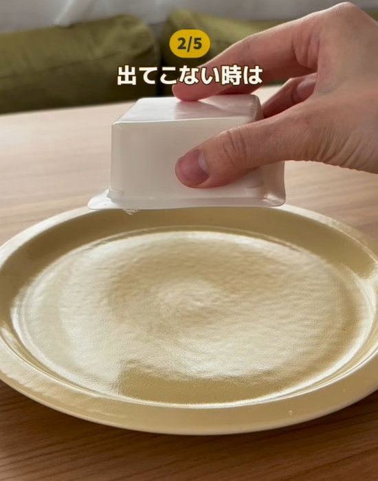 パック豆腐の中身をお皿に出そうとする様子