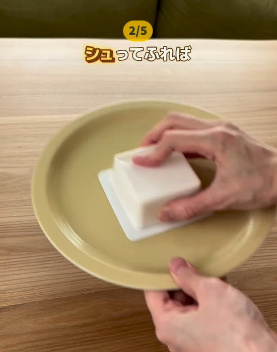 お皿の上にパック豆腐を置いて振る様子
