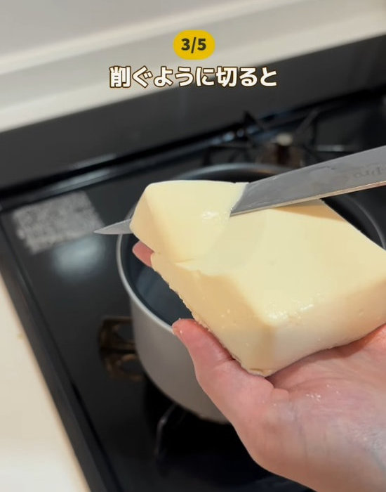 手のひらの上で豆腐を削ぐ様子