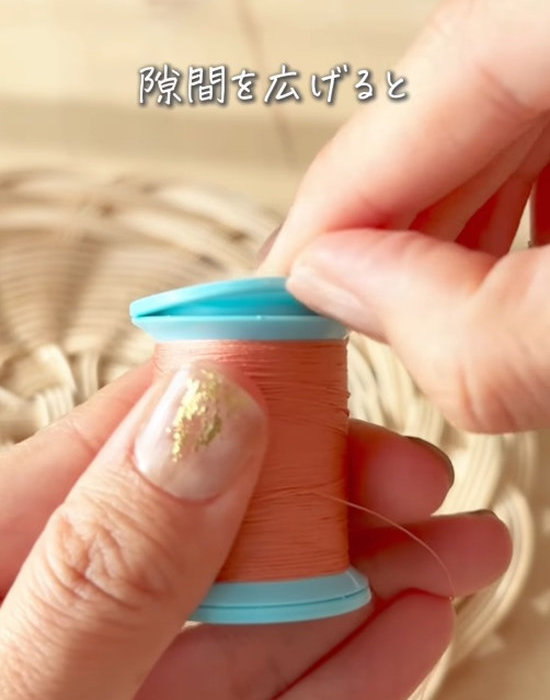 糸巻きの端をつまむ様子