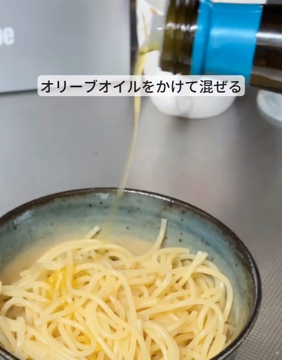 パスタにオリーブオイルをかけている様子