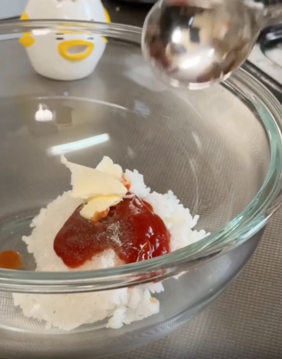 耐熱容器にご飯、ケチャップ、塩コショウ、バターを入れる様子