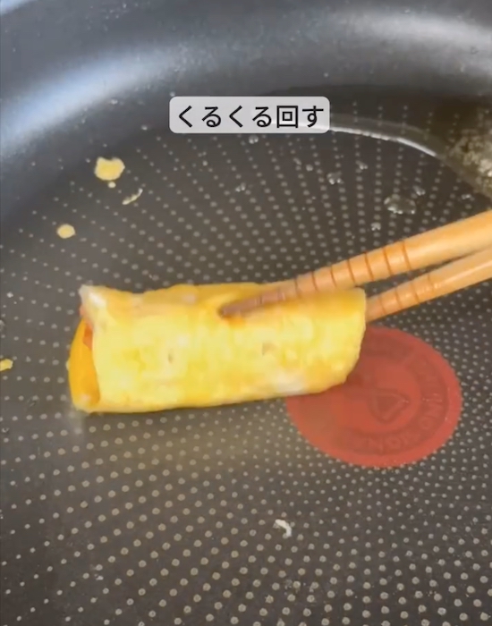 フライパンでご飯を卵で包む様子